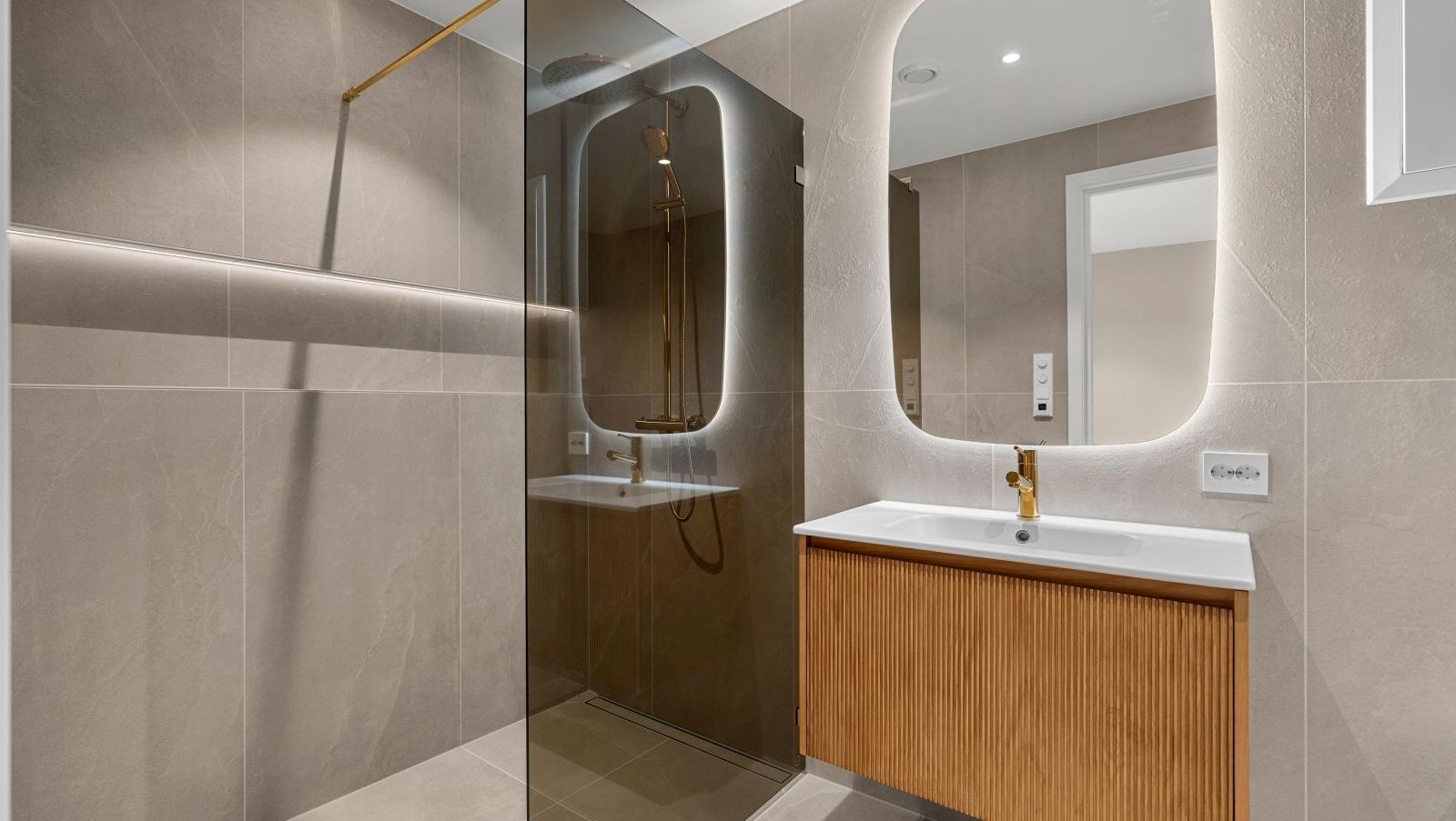 Bad med frittstående badekar, plante og stort bilde på veggen.