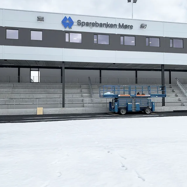 Bygg med Sparebanken Møre-skilt over tribune, snødekt område foran.