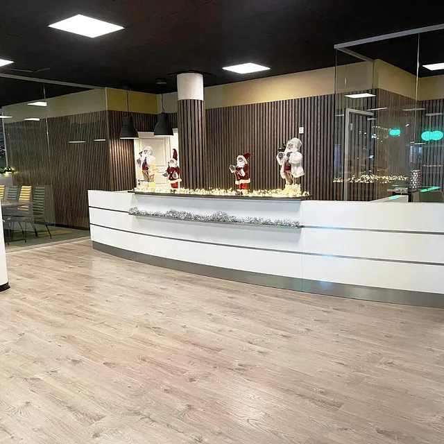 Resepsjonsområde med moderne skranke og julepyntede nisser på disken.