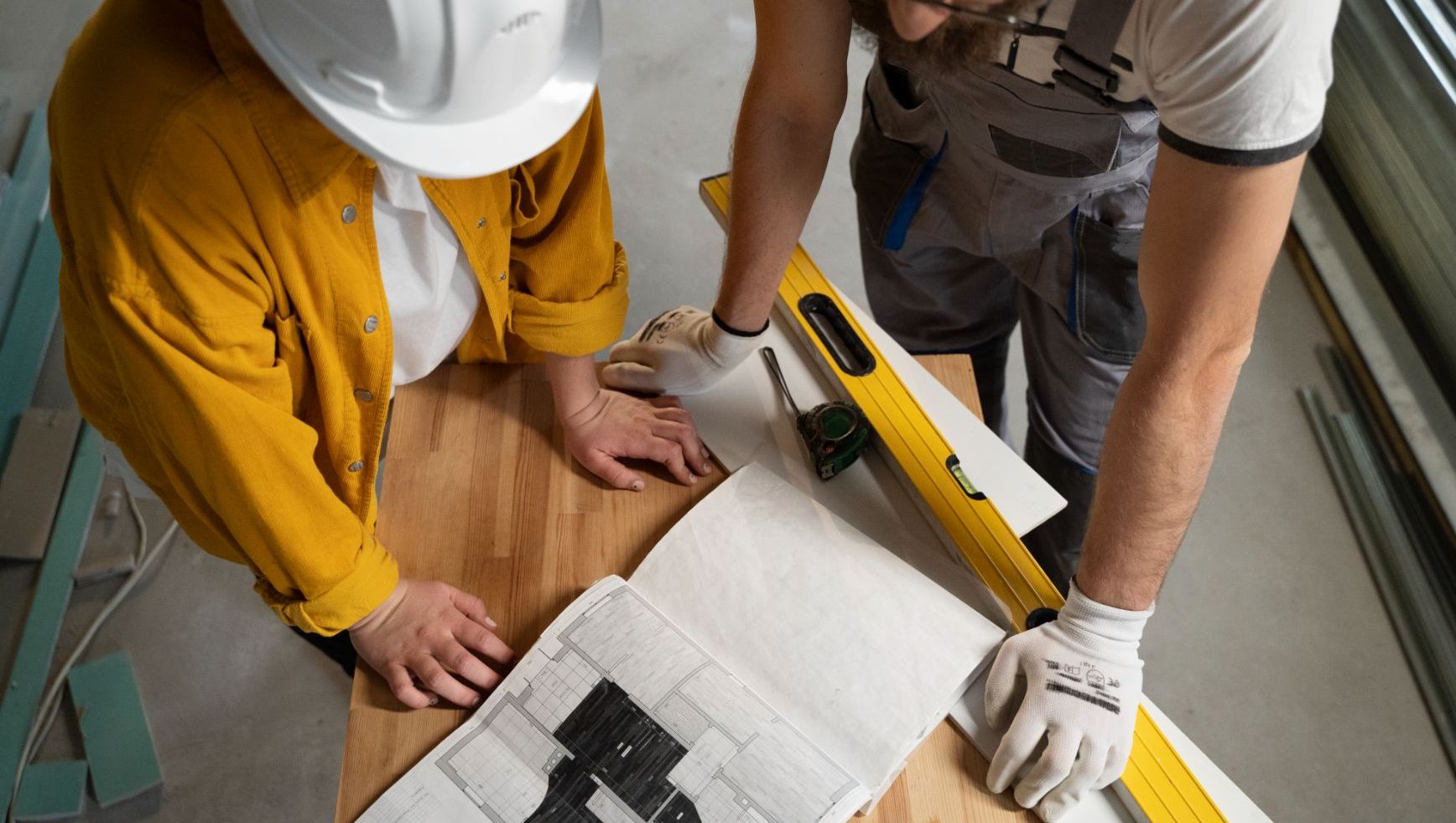 To arbeidere ser på byggeplaner