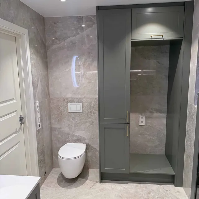 Bad med vegghengt toalett og innebygde skap i stilrent og moderne design.